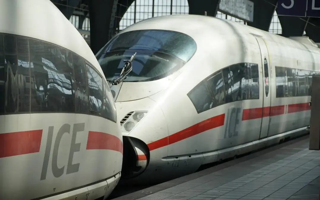 High-speed ICE train at a platform with a white body and red stripe along the side.